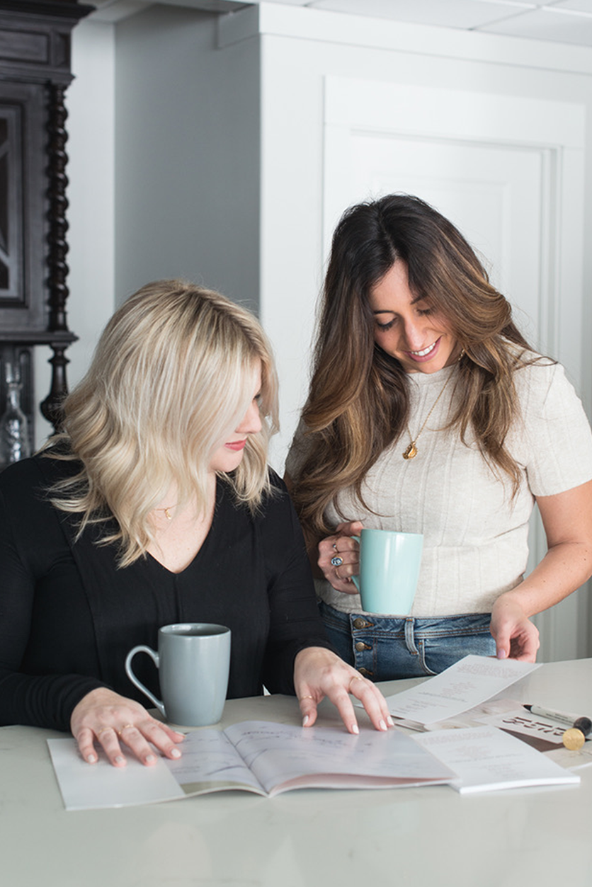 Photo of Cailyn and Jaclyn looking at price list